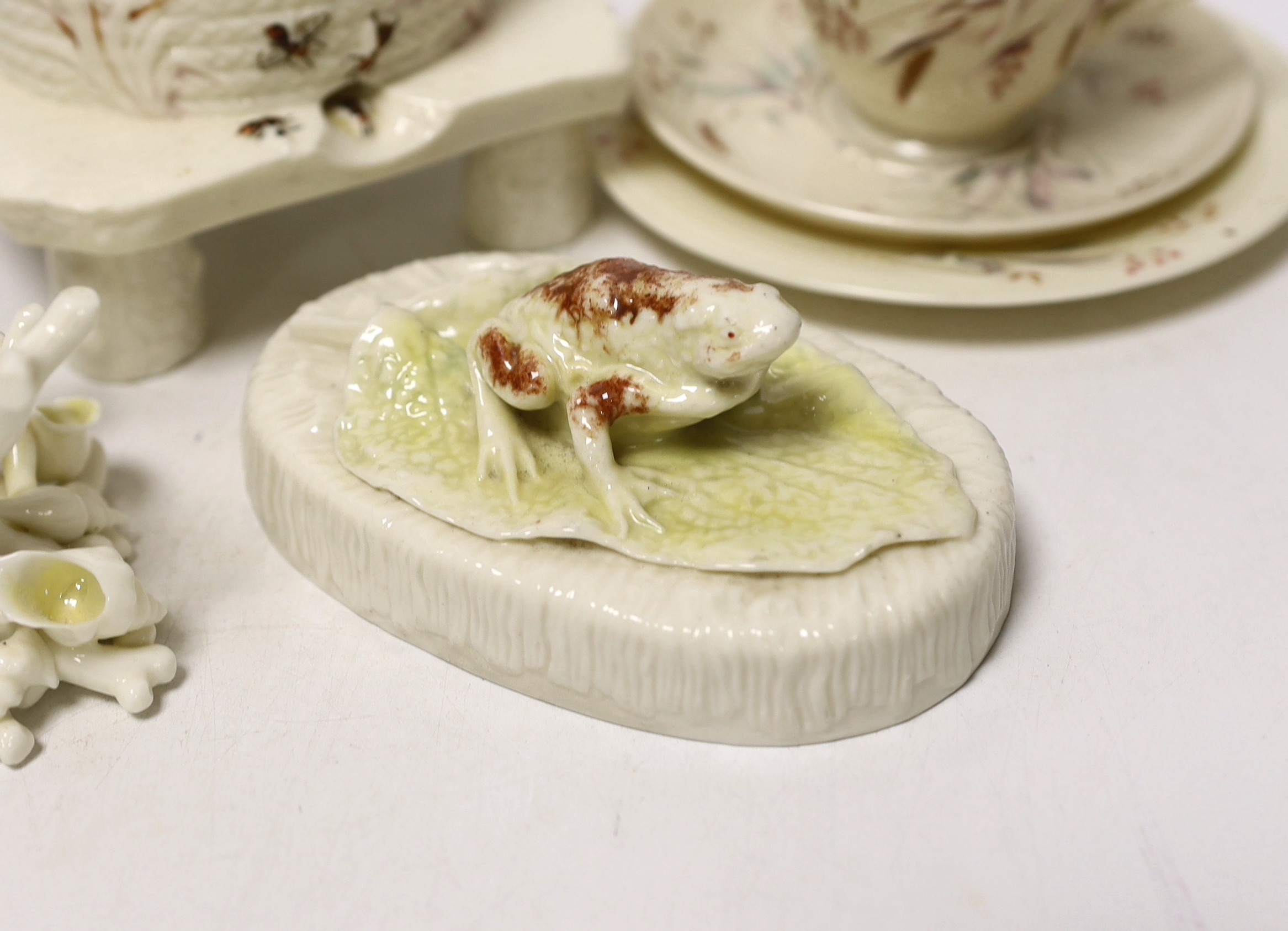 A small quantity of 1st and 2nd period Belleek including a ‘frog’ paperweight and a ‘beehive’ honey jar together with a related reference book by Marion Langham